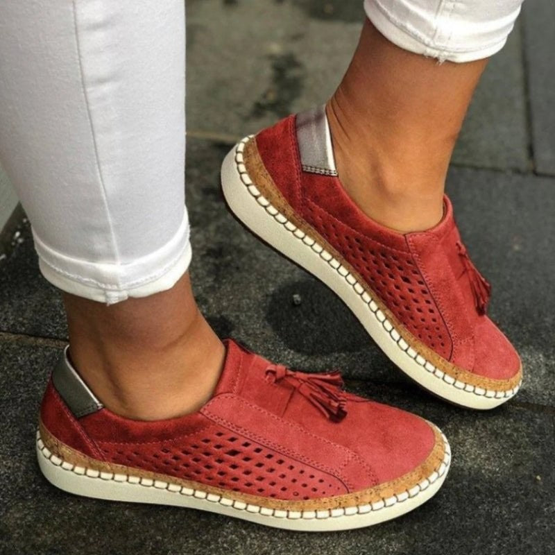 brick red suede slip-on sneakers featuring cutout perforations and cork trim