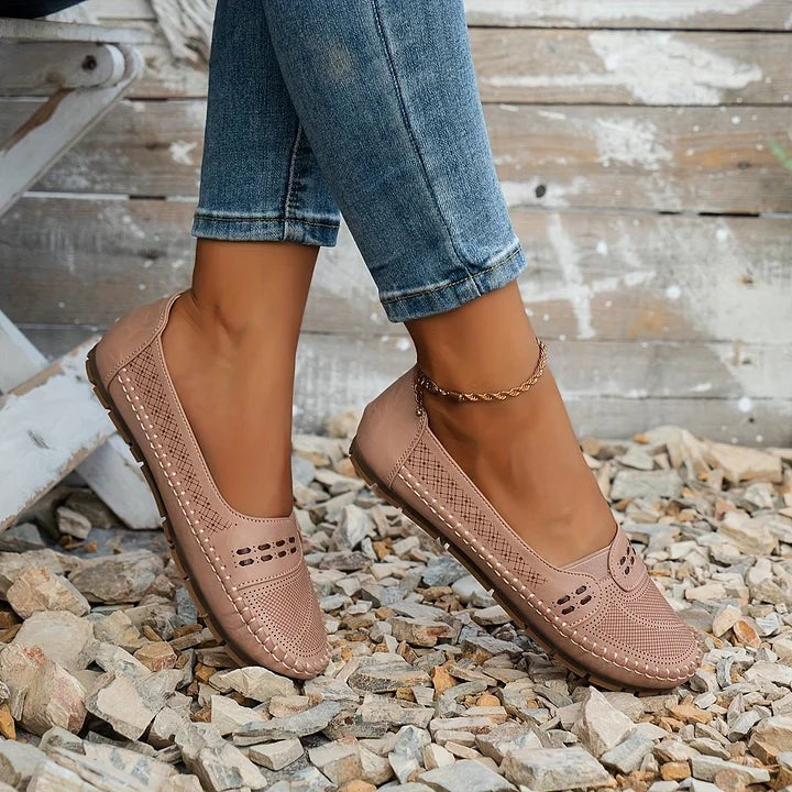 Dusty rose flats with cutout detailing resting against tree bark