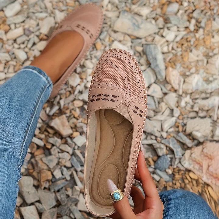 Blush pink slip-on flats with cutout accents and whipstitch edging