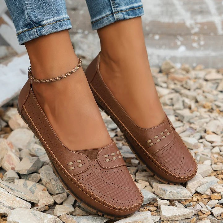 Brown leather slip-on flats with perforated toe and stitched edges