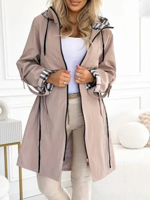 Beige long trench coat featuring plaid-lined hood and cuffs