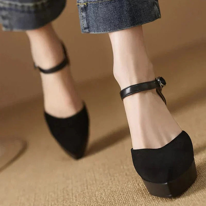 Side profile of black suede pumps highlighting chunky heel shape