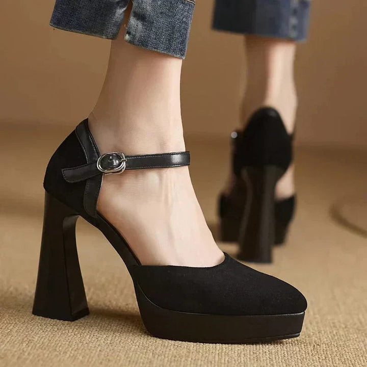 Matching pair of tan suede platform pumps displayed on wood stump