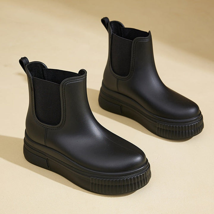 Black Chelsea rain boots with thick ridged platform and elastic gusset
