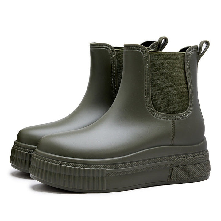 Angled view of olive green rubber Chelsea boots with textured platform sole