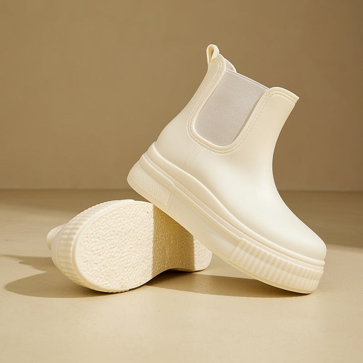 Ivory rubber Chelsea boots displayed side by side showing ribbed outsole