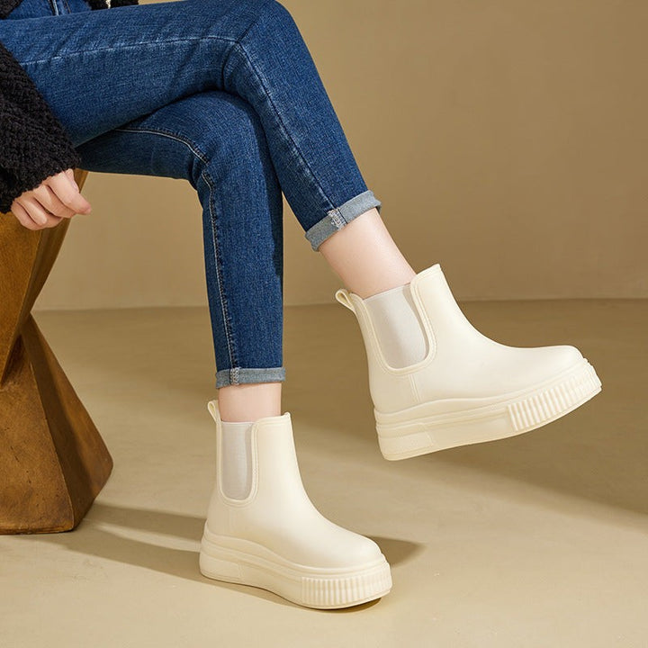 Model wearing ivory platform Chelsea boots with rolled-up denim jeans