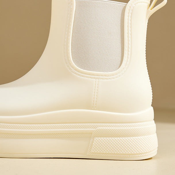Close-up of ivory Chelsea boot heel showing elastic panel and ridged sole