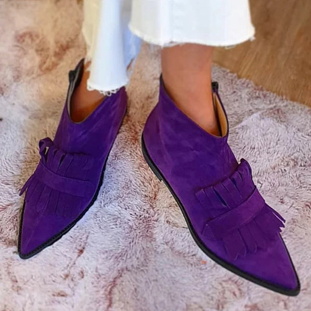 Close-up of purple suede fringe ankle boots featuring a sleek pointed toe