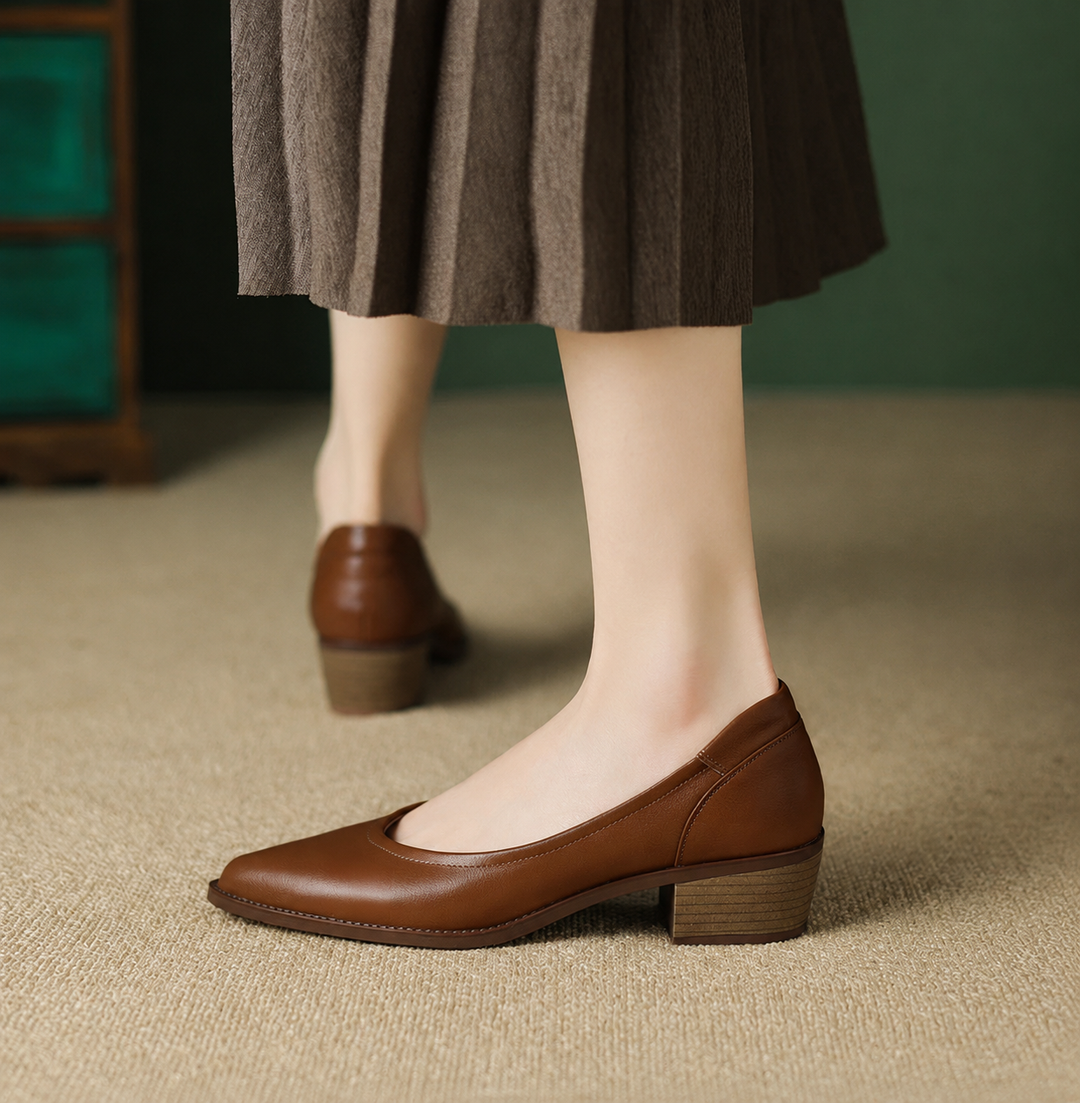 Brown block heel pumps with pointed toe, styled with pleated midi skirt