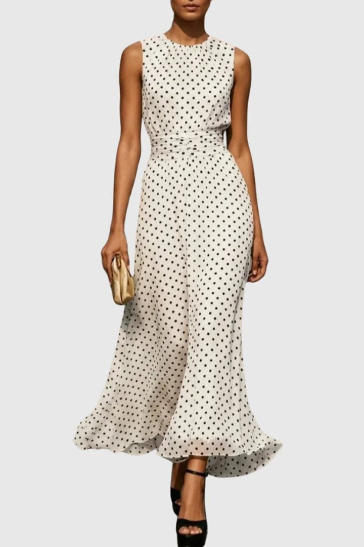 White polka dot sleeveless maxi dress with ruffled flowing hem