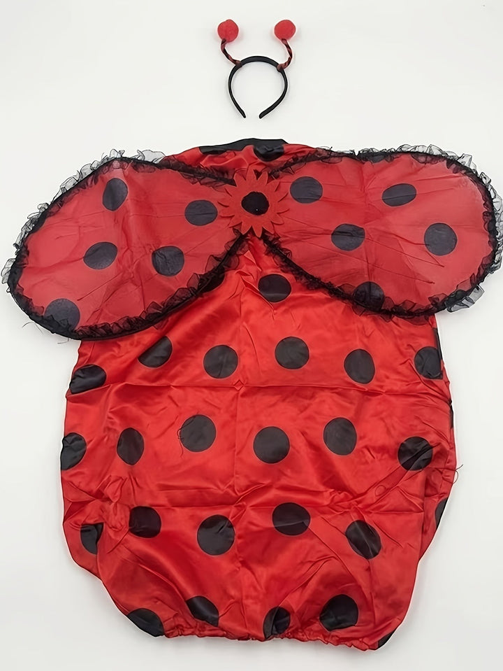 Flat lay of ladybug costume set with polka dot tunic, wings, and antenna headband