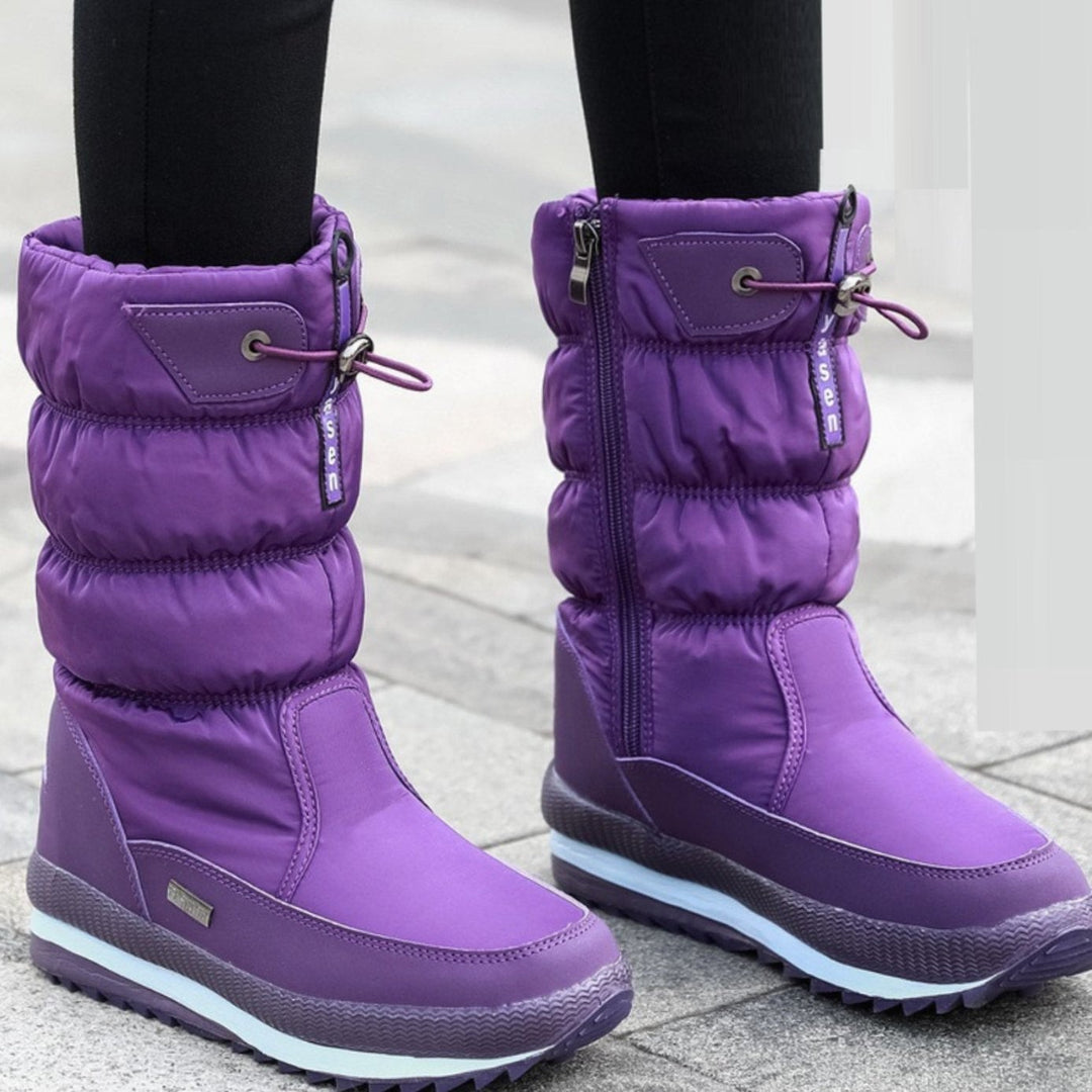 Purple quilted mid-calf snow boots worn with black leggings outdoors