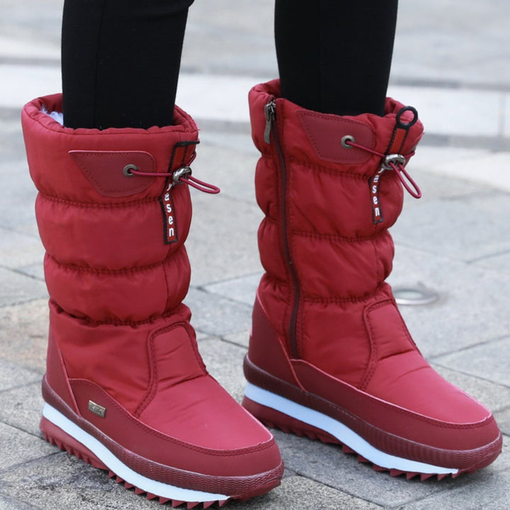 Red quilted mid-calf snow boots with zipper closure worn outdoors