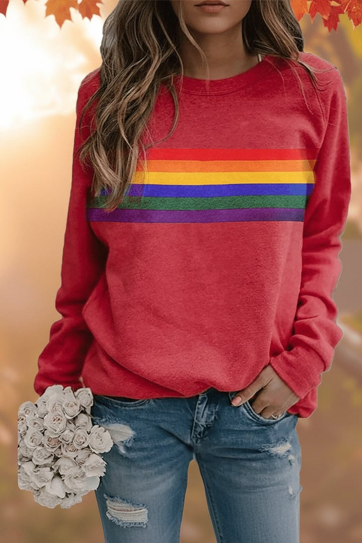 Red pullover sweatshirt with vintage rainbow stripe across chest, worn with ripped jeans