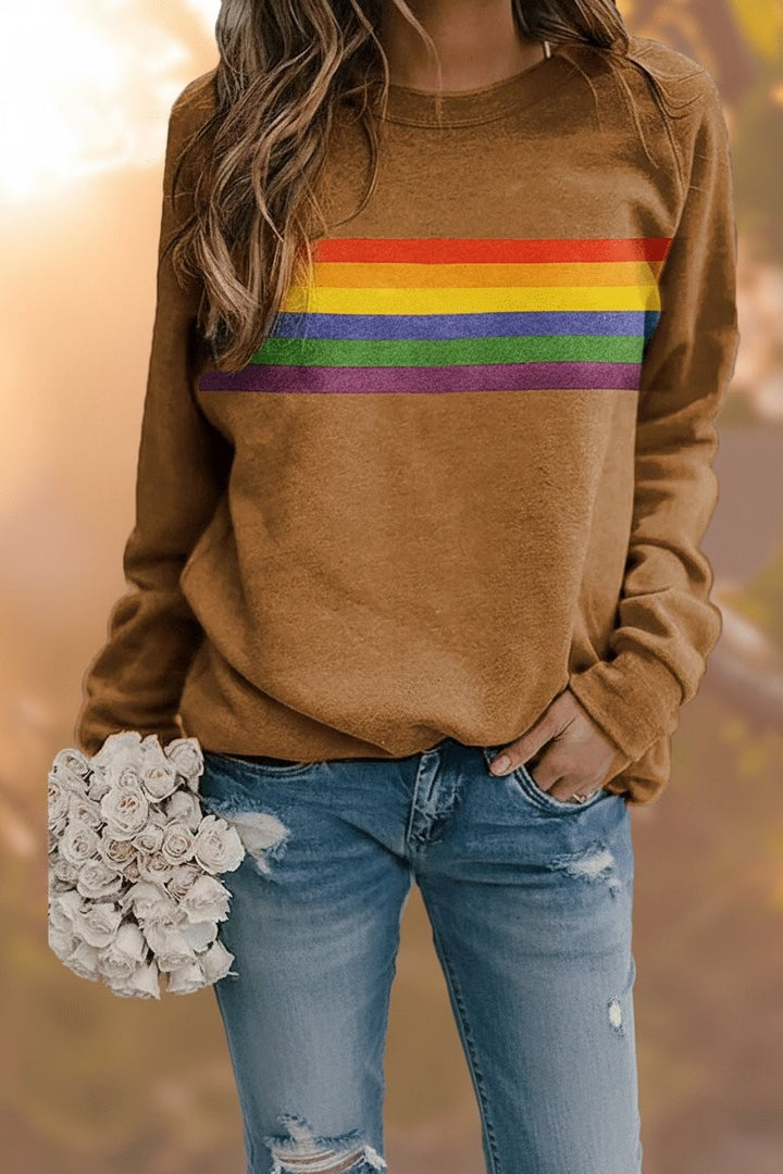 Camel rainbow-striped pullover sweatshirt paired with ripped denim jeans, close-up view