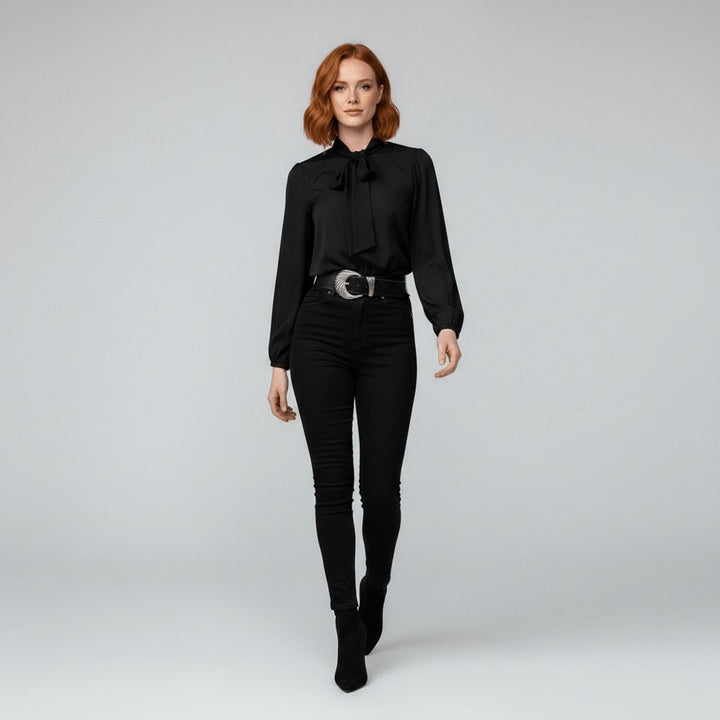 black tie-neck blouse worn with skinny jeans and western-style belt