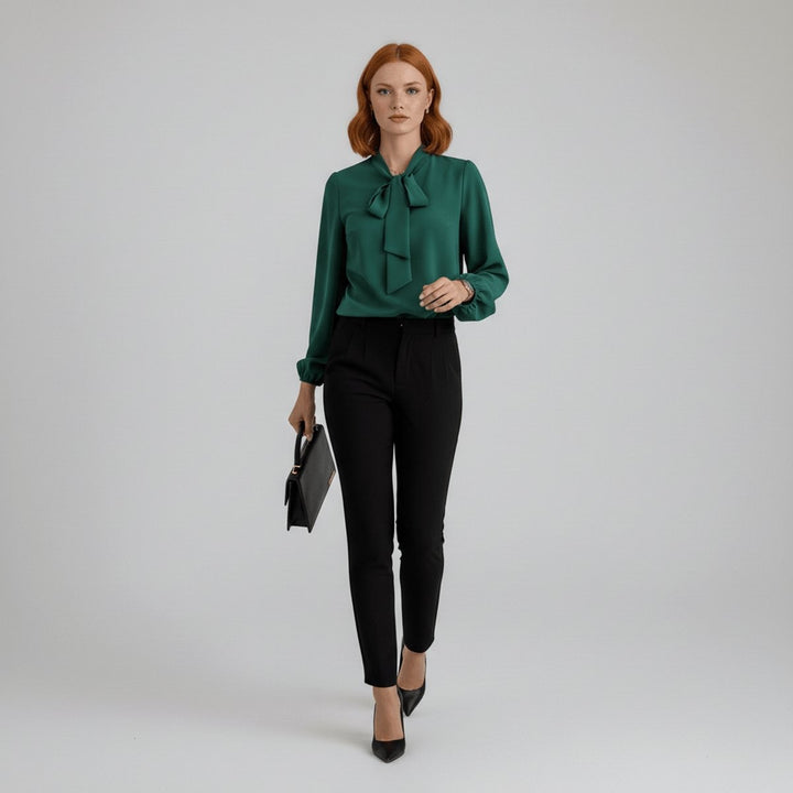 emerald green tie-neck blouse paired with black slim trousers and pumps