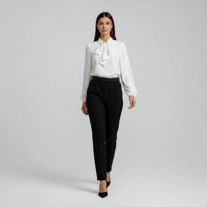 white tie-neck blouse styled with black pleated trousers and pointed heels