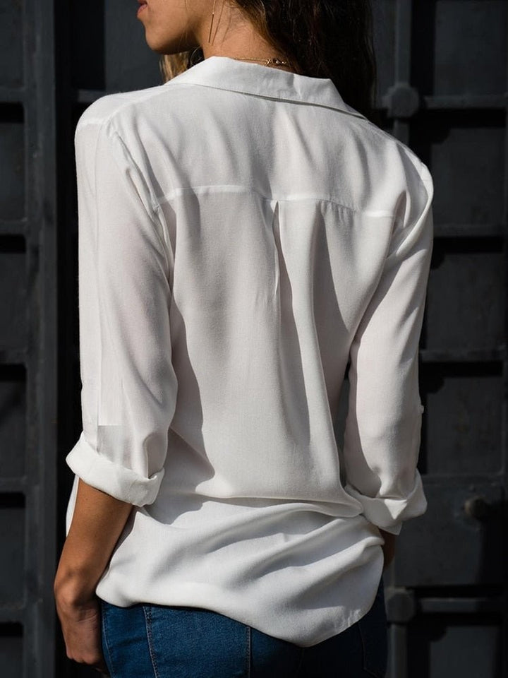 back view of white relaxed-fit blouse with rolled sleeves and curved hem
