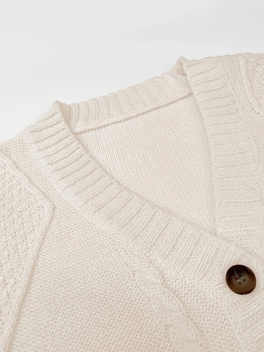Close-up of white cardigan V-neck collar with tortoiseshell button