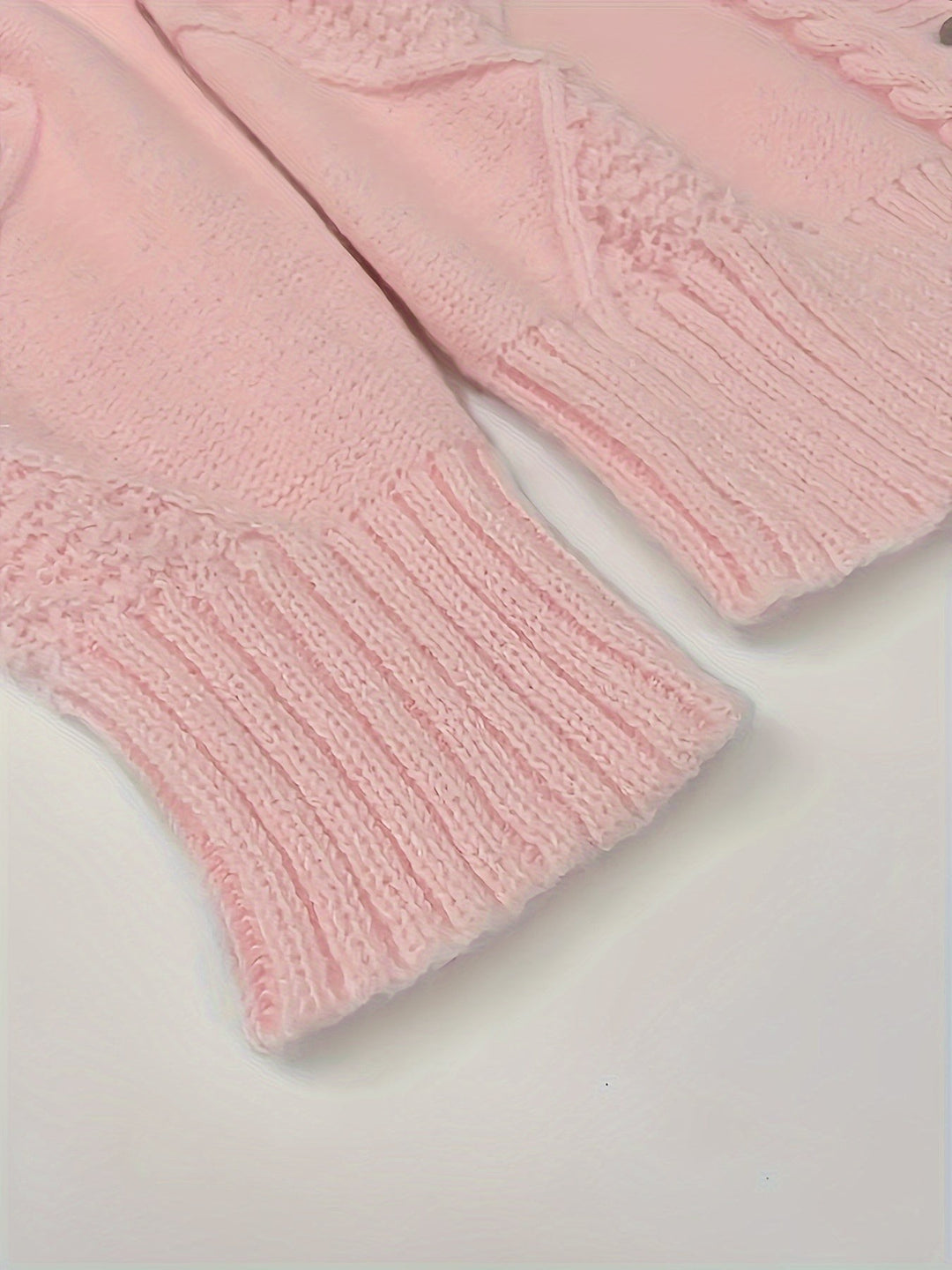Close-up of pink knit sweater cuff with ribbed detailing