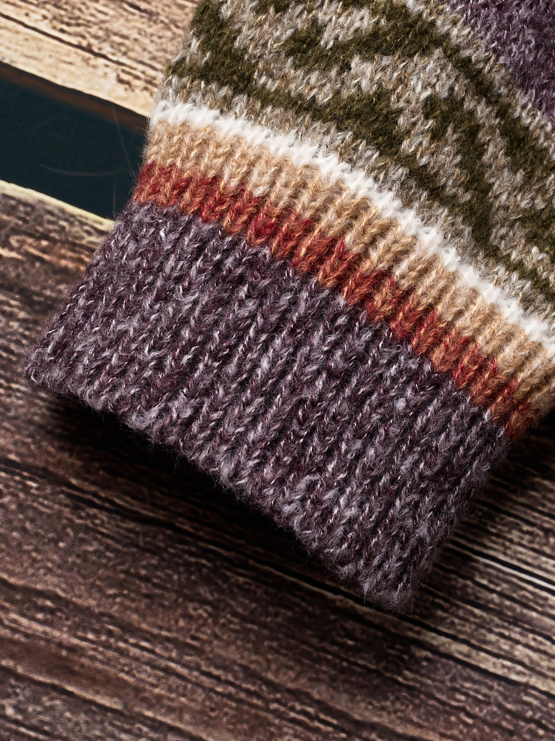Folded purple knit fabric texture detail on patterned cardigan