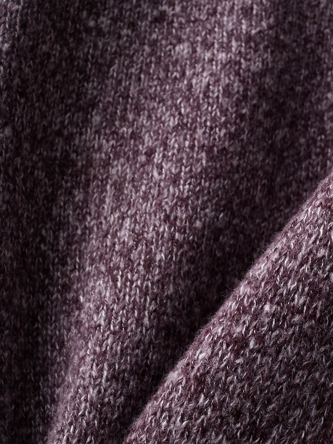 Folded purple knit fabric close-up showing soft ribbed texture