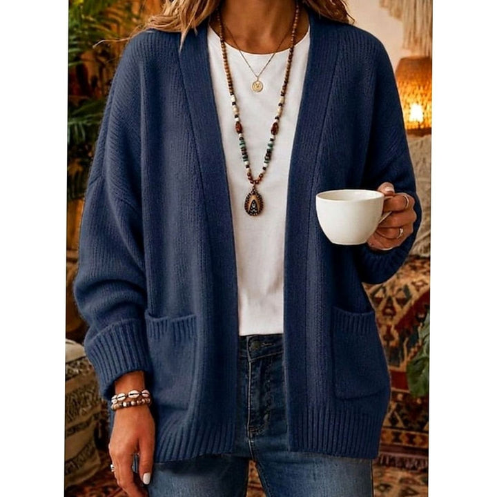 Navy blue oversized knit cardigan with front pockets worn over jeans
