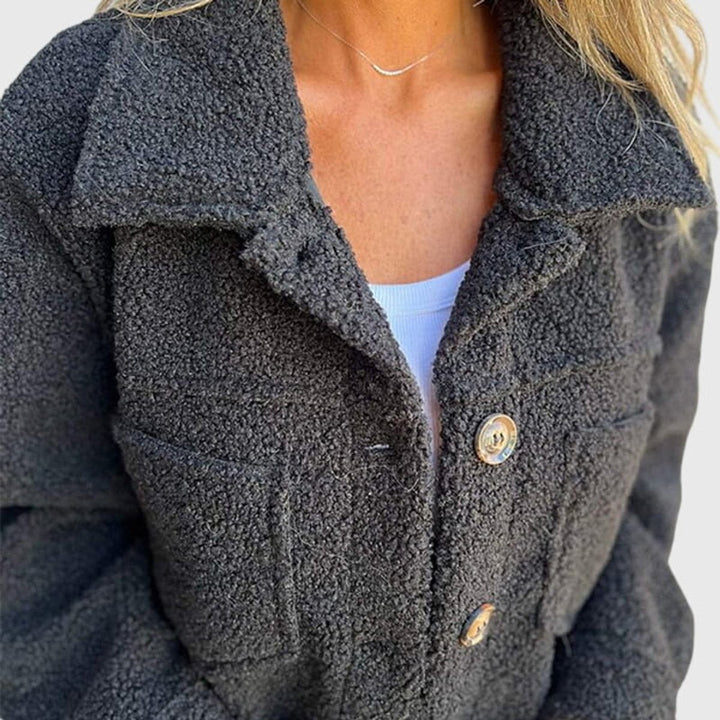 Close-up view of black sherpa fleece jacket button and collar detail
