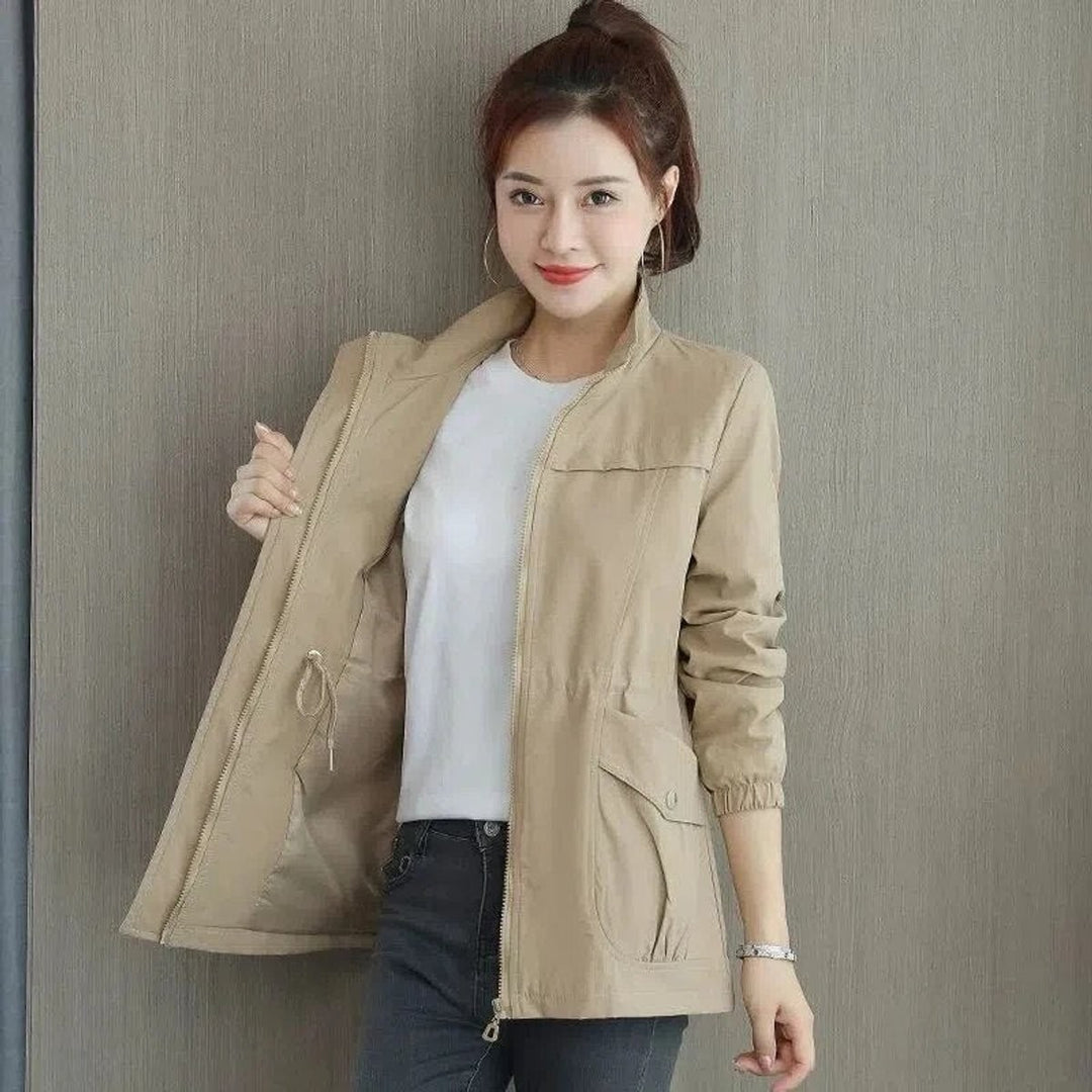 Woman wearing khaki zip-up bomber jacket with drawstring waist and cargo pockets