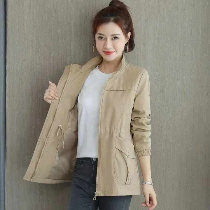 Woman wearing khaki zip-up bomber jacket with drawstring waist and cargo pockets