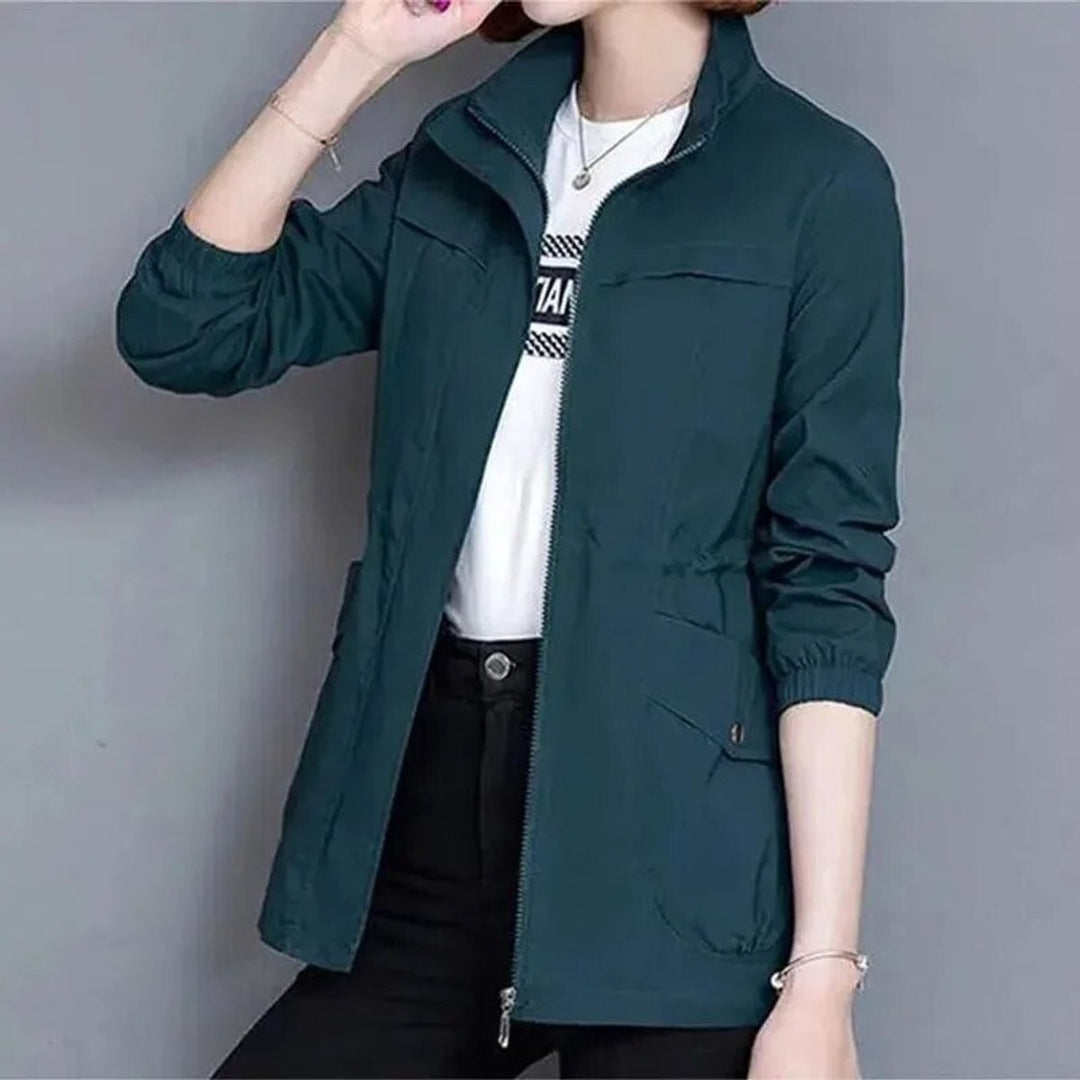 Dark teal bomber jacket with stand collar worn open over white tee
