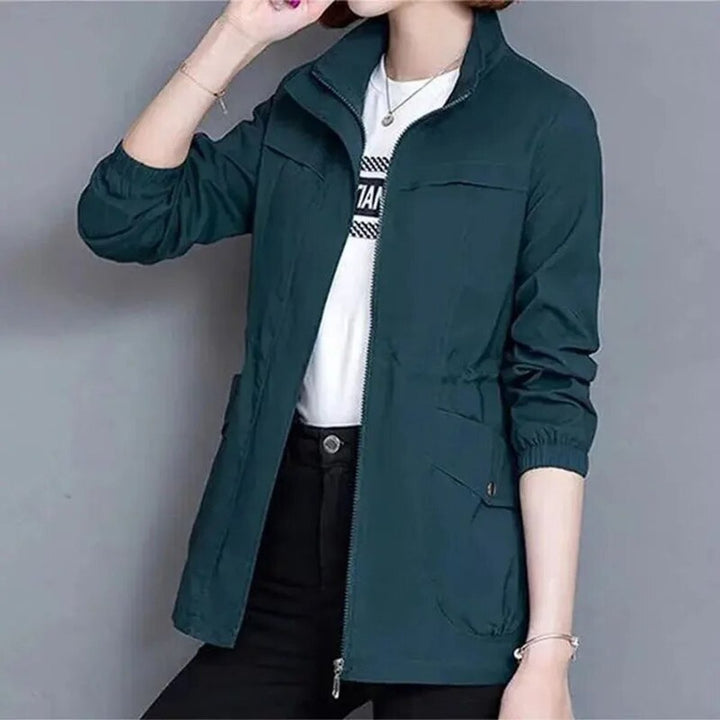 Dark teal bomber jacket with stand collar worn open over white tee