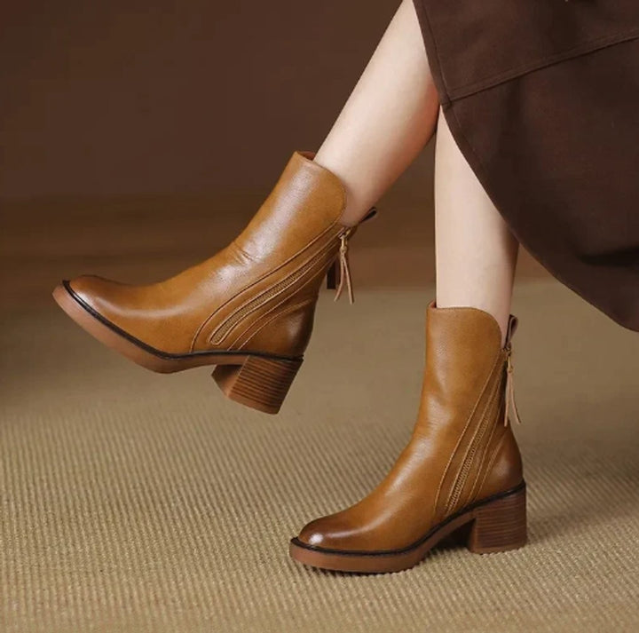 Woman wearing camel leather ankle boots with block heel and side zipper