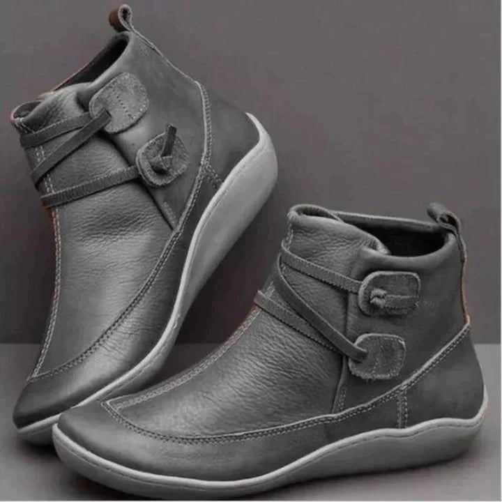 Gray leather ankle boots with adjustable buckle strap and white sole