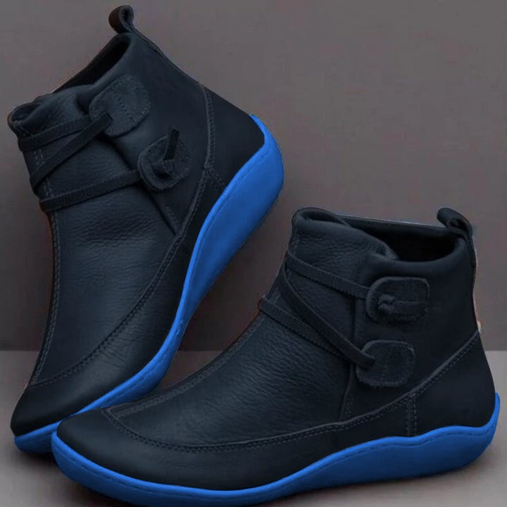 Black leather ankle boots with contrast blue sole and buckle strap