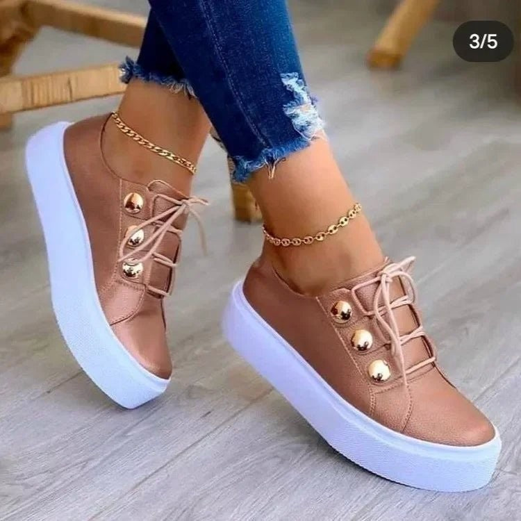 Rose gold platform sneakers featuring metallic stud embellishments and white sole