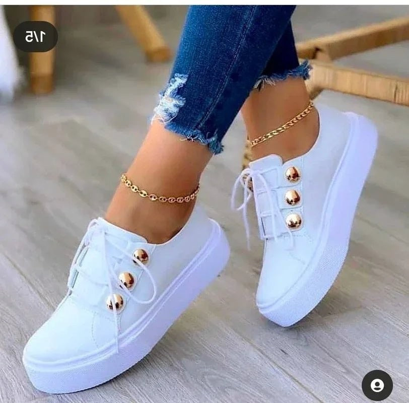 White lace-up sneakers featuring gold studs and round-toe platform design