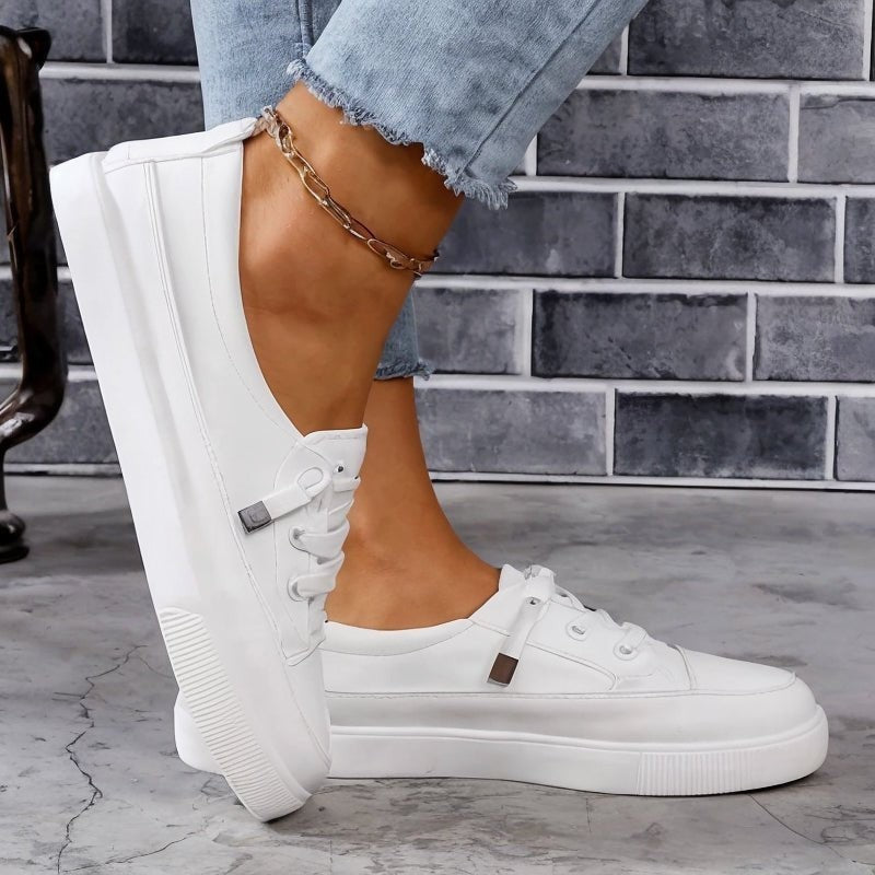 Side view of white lace-up sneakers with chunky platform outsole