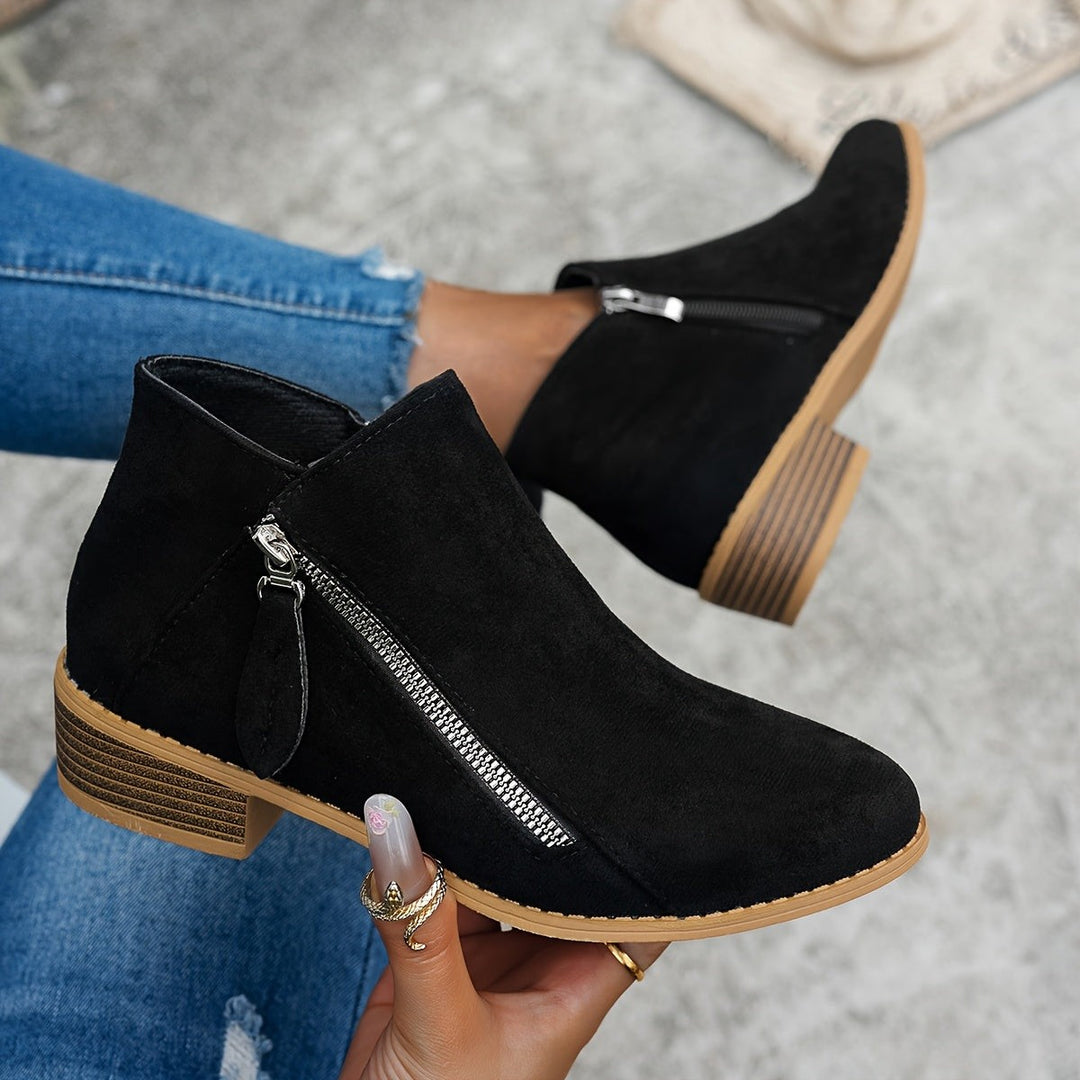 black suede side-zip ankle boots worn with distressed skinny jeans