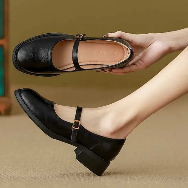 Black leather Mary Jane flats shown from top and side with ankle strap
