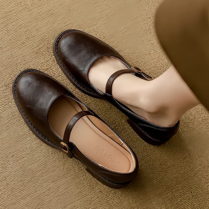 Dark brown leather Mary Jane shoes with round toe, worn on both feet