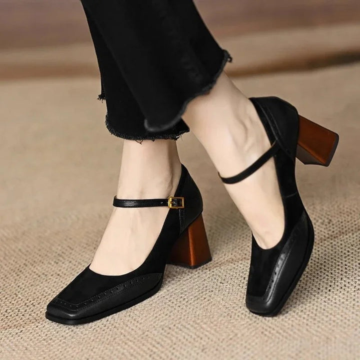 side view of black suede pumps with brown block heel and buckle strap