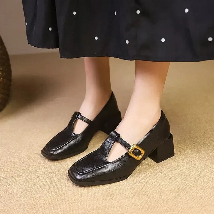 Black leather Mary Jane heels featuring square toe and gold buckle detail