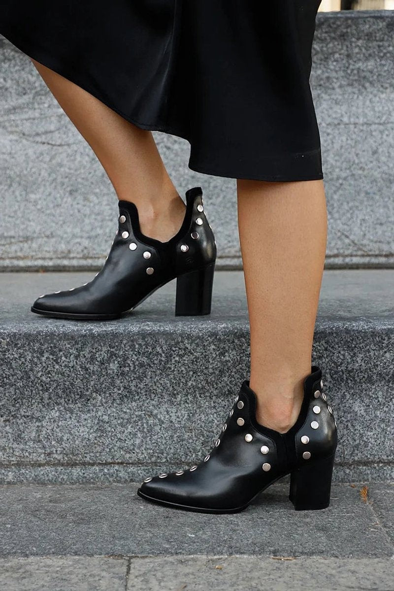 studded block-heel ankle boots worn on stairs with black dress