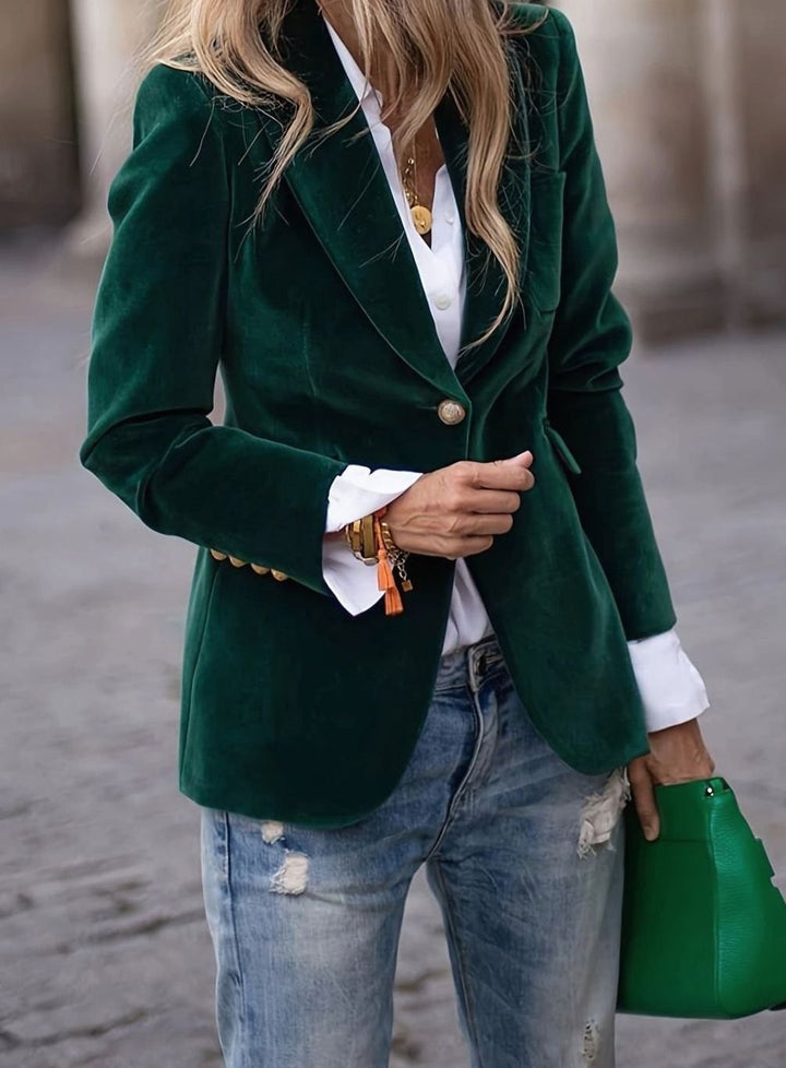 Emerald green velvet single-button blazer paired with white shirt and denim