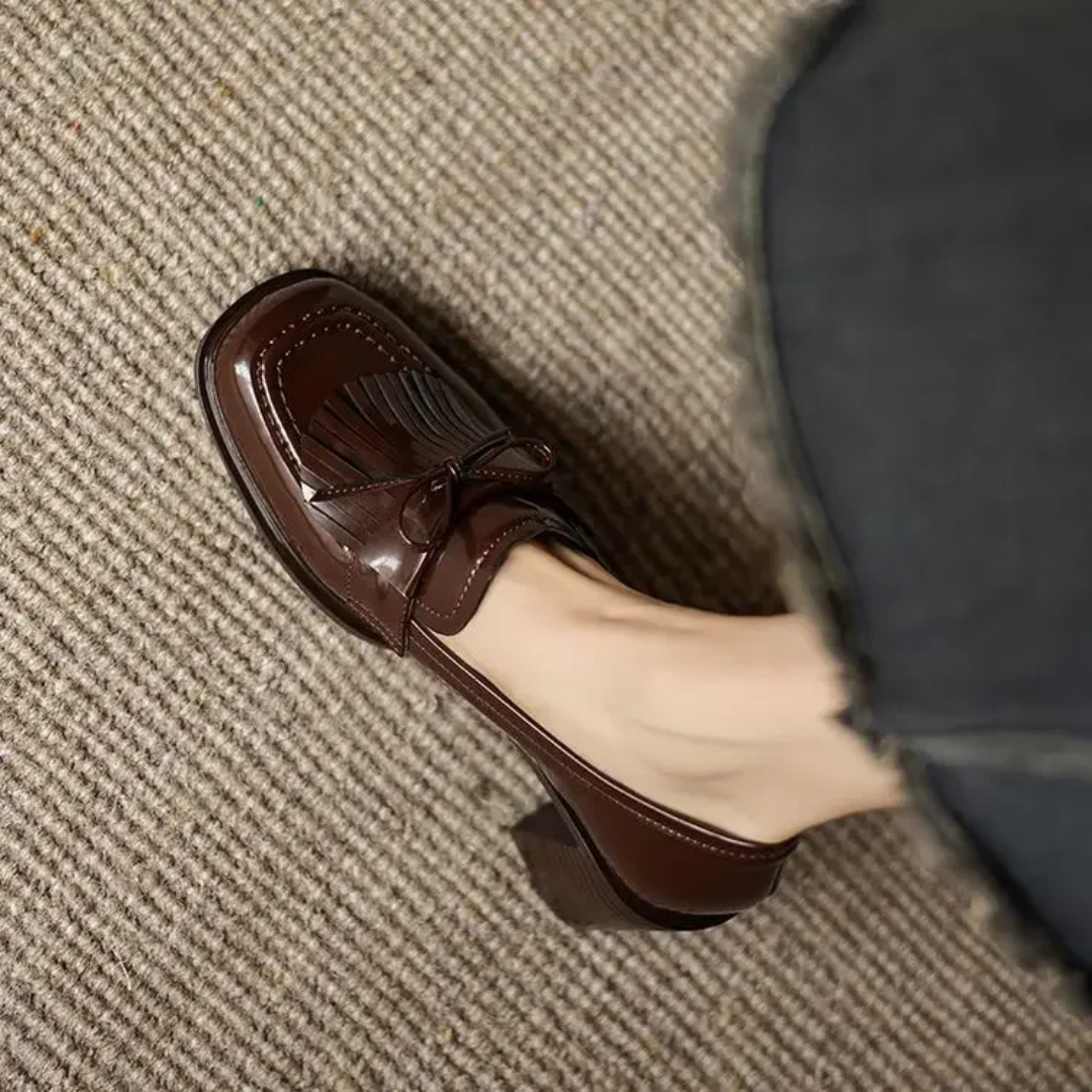 close-up of brown tassel loafer pump with stacked block heel