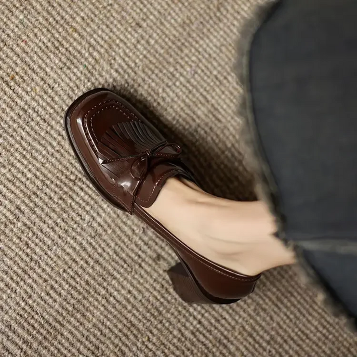 close-up of brown tassel loafer pump with stacked block heel