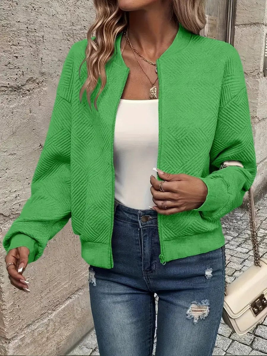 Green quilted cropped bomber jacket layered over white top